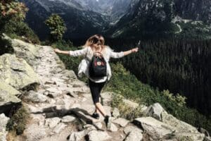 Woman hiking with backpack in mountains.