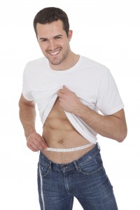 Muscular man measuring waist