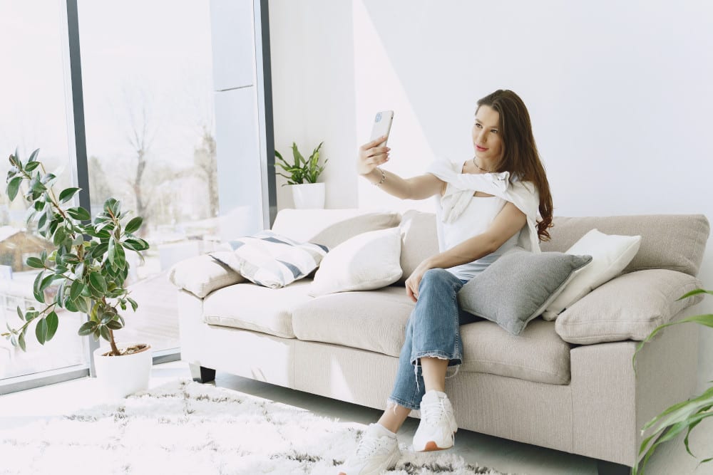 Woman taking a selfie on the couch.